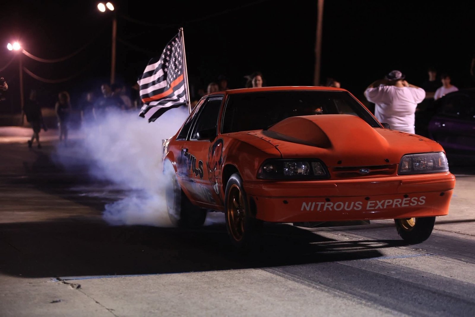 Red drag car doing a nighttime burnout